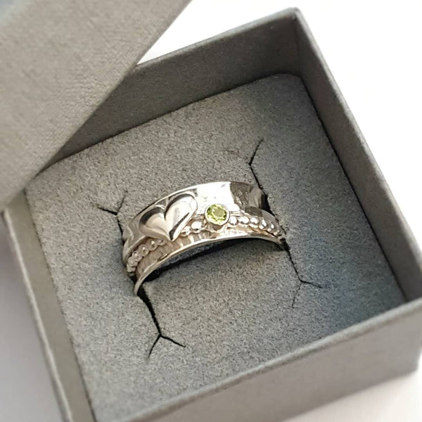 Peridot and heart spinner ring